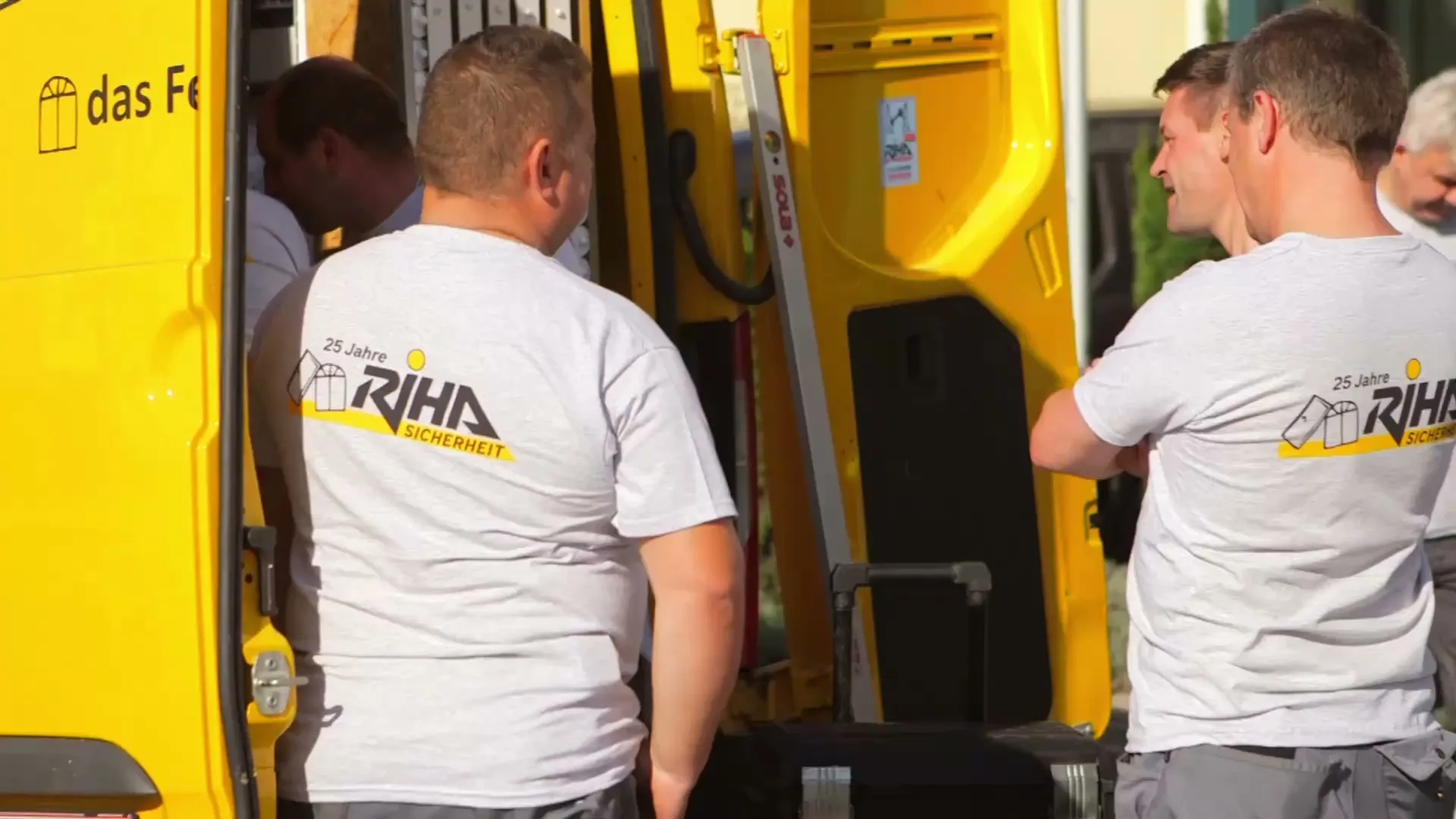 Zwei Monteure von RIHA Sicherheit am geöffneten gelben Servicefahrzeug